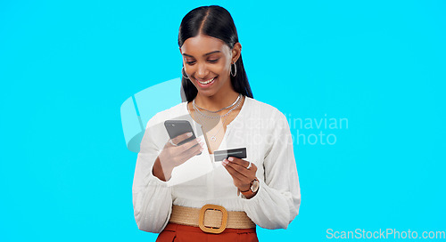 Image of Woman, studio and phone with credit card for online shopping, sale or discount by blue background. Gen z girl, smartphone and smile with ecommerce, customer experience and fintech on web store ux