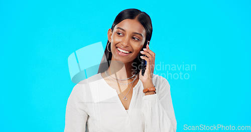Image of Happy phone call, business woman and studio with a Indian female talking and speaking. Mobile communication, online discussion and networking of a young person smile with isolated blue background