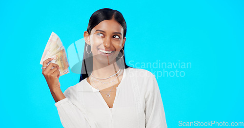 Image of Rich, happy and face of a woman with money isolated on a blue background in a studio. Smile, wealth and a portrait of a girl fanning with cash, lottery jackpot and dollars from a bonus on a backdrop