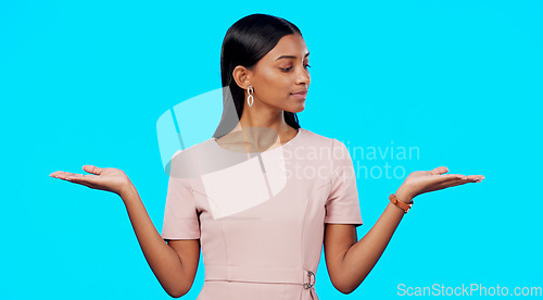 Image of Choice, option or decision and a woman on a blue background in studio with a hand gesture. Portrait, balance and scale with an attractive young female weighing up the pros and cons of a variable