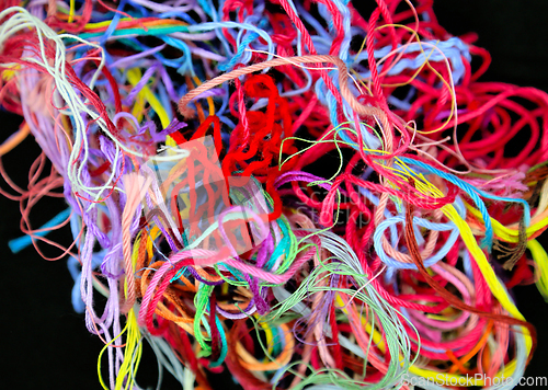 Image of Close-up of multicolored tangled threads for needlework on black