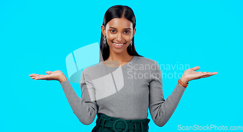 Image of Choice, option or decision and a woman on a blue background in studio with a hand gesture. Portrait, balance and scale with an attractive young female weighing up the pros and cons of a variable