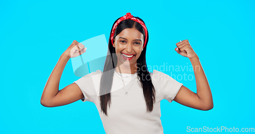 Image of Flexing, empowerment and woman showing arm muscle, strong and happy person isolated in a studio blue background. Bicep, strength and portrait of an excited female for body positivity