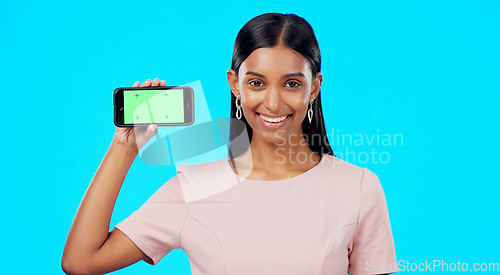 Image of Chromakey, green screen and portrait of woman holding phone for product place, logo and mobile app advertising. Smile, happy and professional female isolated in a studio blue background