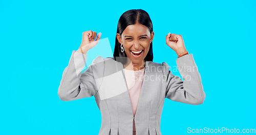 Image of Yes, winning and woman cheers isolated on blue background celebration, excited and fist pump for lotto. Wow, happy winner or indian person face to celebrate prize, competition or bonus news in studio