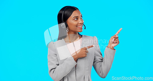 Image of Call center, portrait or happy woman in studio pointing for promotion or product placement on blue background. Smile, mockup space or Indian girl in headset at technical support or customer services