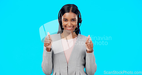 Image of Call center, portrait or happy woman with thumbs up in studio for agreement on blue background. Smile, mockup space or Indian girl with like, success or yes hand sign at telecom crm customer services