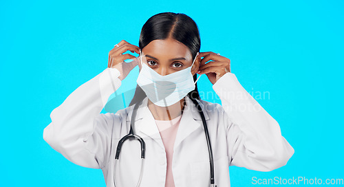 Image of Studio woman, face mask and covid doctor, female surgeon or nurse for disease support, healthcare or pandemic help. Hospital policy compliance, safety portrait or medical person on blue background