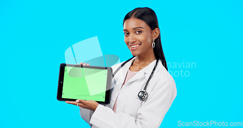 Image of Tablet, green screen and doctor face isolated on blue background telehealth, medical or service software app. Healthcare professional or indian person on digital technology, studio and mockup space