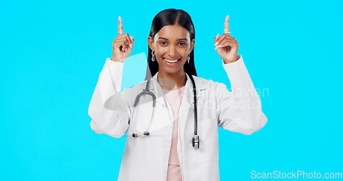 Image of Hospital doctor, studio and happy woman point at medical promotion, healthcare notification or clinic announcement mockup. Nurse portrait, advertising surgeon and marketing person on blue background