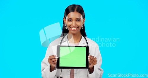 Image of Tablet, green screen and doctor face isolated on blue background telehealth, medical or service software app. Healthcare professional or indian person on digital technology, studio and mockup space