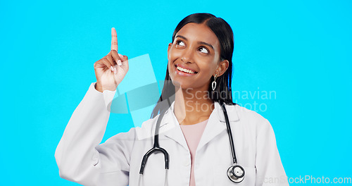 Image of Healthcare doctor, smile and woman point at medical promotion, hospital notification or clinic announcement mockup. Nurse portrait, studio advertising surgeon and marketing female on blue background