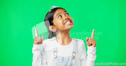 Image of Green screen, mockup and child pointing up excited, happy and isolated in a studio background. Deal, sale and young girl or kid hands showing at brand, product placement or branding logo