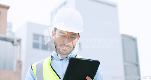 Image of Construction worker holding a digital tablet while doing inspection. Organized male engineer or technician in a hardhat checking project plan with latest tech. Worker looking or overseeing operations