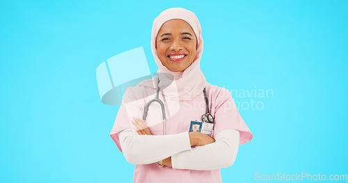 Image of Muslim woman, face and nurse smile with arms crossed in studio isolated on blue background mockup. Portrait, medical professional and confident, happy and proud Islamic person or surgeon from Turkey.