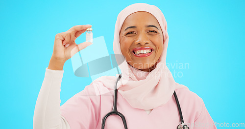 Image of Nurse, healthcare and vaccine with a muslim woman on a blue background in studio for treatment. Medical, product and insurance with a young female medicine professional holding a glass bottle
