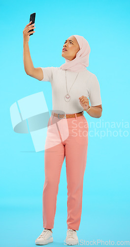 Image of Woman, phone and lost signal in studio isolated on a blue background for connection problem. Cellphone, network issue and confused Muslim person with glitch, error or no service, 404 and web search.