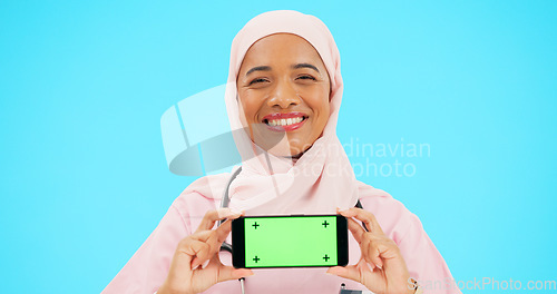 Image of Phone, green screen and woman doctor isolated on blue background healthcare, tracking marker and mockup space. Face of nurse or muslim person with medical mobile app for advertising video in studio