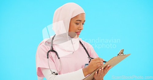 Image of Woman, doctor and writing on clipboard in studio for information or medical record. Islamic or muslim female and professional nurse in hijab with list for healthcare insurance on blue background