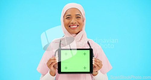 Image of Woman, doctor and tablet green screen in studio for website information or medical record app. Muslim female or professional nurse in hijab and mobile device for online healthcare on blue background