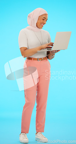 Image of Happy, email and a Muslim woman with a laptop for work isolated on a blue background in a studio. Smile, online and an Islamic employee typing on a computer, sending response and reading on the web