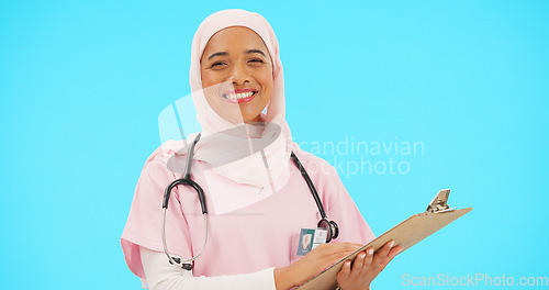 Image of Woman, doctor and clipboard portrait in studio for information or medical records. Islamic or muslim female and professional nurse in hijab with smile and document for healthcare on blue background