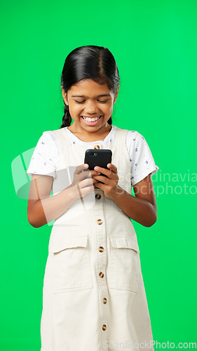 Image of Happy, green screen and girl with smartphone, typing and laughing against a studio background. Mobile app, young person and female child with cellphone, connection and communication on social media