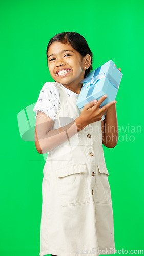 Image of Excited, gift and face of a girl on a green screen isolated on a studio background. Shaking, happy and portrait of a girl with excitement about a birthday, Christmas or holiday present on a backdrop