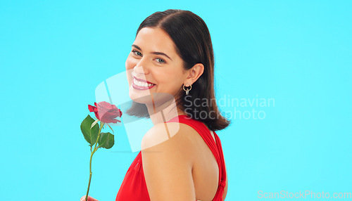 Image of Face, rose and woman in studio on blue background with fresh, floral or romantic gesture on mockup. Portrait, flower and female with gift, present and romance, valentines or caring offering isolated