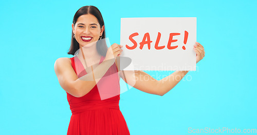 Image of Woman holding sale poster isolated on blue background for retail, shopping or customer discount announcement. Happy face of person with fashion promotion, deal or cardboard sign in studio advertising