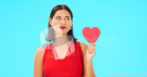 Image of Paper heart, happy woman and face on blue background, studio and backdrop. Portrait of female model in red dress with shape of love, trust and romance for valentines day, flirting and elegant smile