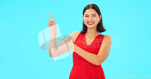 Image of Smile, face and woman on blue background pointing to mockup, studio and color backdrop. Portrait of happy female model advertising promotion, discount sales or brand presentation of offer coming soon