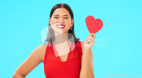 Image of Paper heart, happy woman and face on blue background, studio and backdrop. Portrait of female model in red dress with shape of love, trust and romance for valentines day, flirting and elegant smile