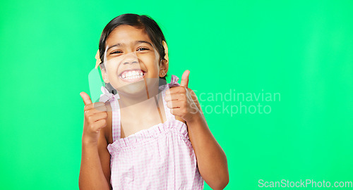 Image of Happy, excited and face of a child with thumbs up on a green screen isolated on a studio background. Success, review and portrait of a girl showing an emoji hand icon for satisfaction and like