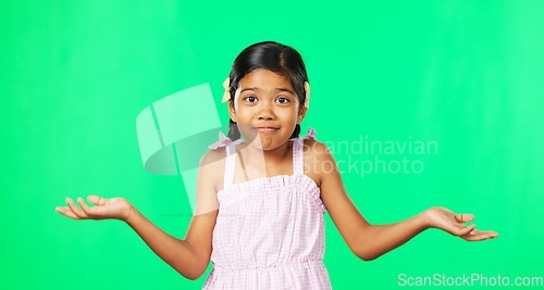 Image of Portrait, happy and a girl shrugging on a green screen background in studio to gesture doubt or whatever. Smile, question and confused with an adorable little female child on chromakey mockup