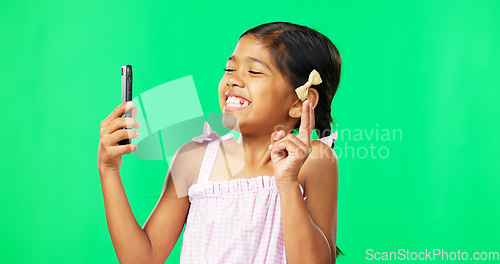 Image of Child, peace and smile for selfie on green screen background for happiness and motivation in studio. Face of happy girl kid with technology for profile picture of connection with hand sign or emoji