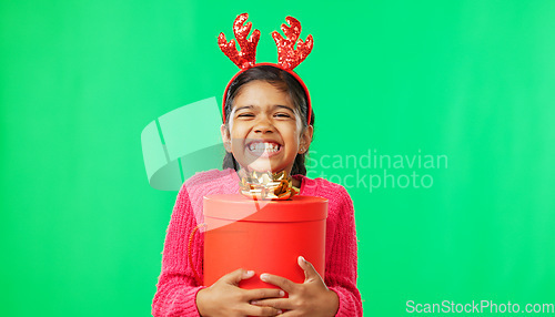 Image of Christmas, gift box and happy with girl in green screen studio for youth, celebration and festive. Present, cheerful and vacation with portrait of child on background for season, holiday or happiness