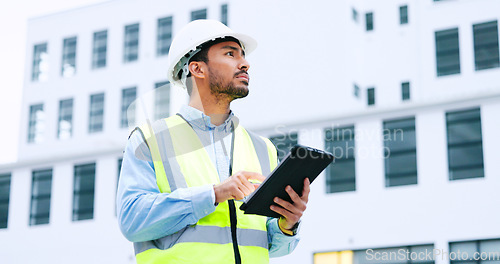 Image of Male engineer checking data on digital tablet and inspecting construction site. Technician in a hardhat doing management and project planning outdoors. Skilled worker looking or overseeing operations