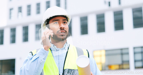 Image of Civil engineer on a phone call while at a construction site discussing a strategy and plan to work on. Close up portrait of confident architect talking with building in the background and copy space