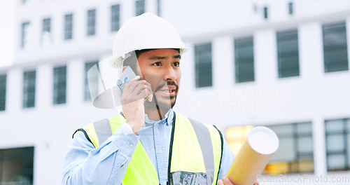 Image of Civil engineer on a phone call while at a construction site discussing a strategy and plan to work on. Close up portrait of confident architect talking with building in the background and copy space