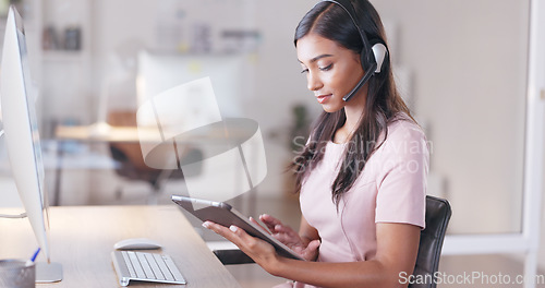 Image of Young female customer service agent working in ecommerce and sales. Business woman working on a tablet in her office while helping and assisting customers online with IT support