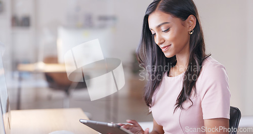 Image of Young happy woman with a digital tablet while relaxing in an office at work. One smiling female student taking pictures to post on social media while sitting alone in a library