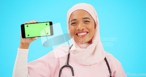 Image of Phone, green screen and doctor woman isolated on blue background for healthcare tracking marker and mockup space. Face of nurse or muslim person with medical mobile app for advertising in studio