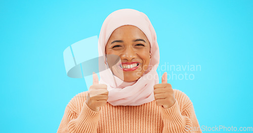 Image of Muslim woman, happy and thumbs up portrait in studio for mockup, advertising or promotion. Islamic female with hand emoji, smile and hijab excited for announcement or sale on blue background