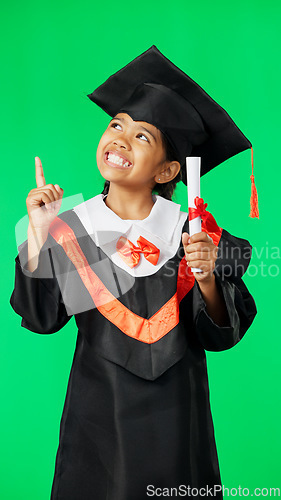 Image of Graduation, education and child point on green screen for graduate, academy ceremony and award. Primary school, student and portrait of happy girl with knowledge, achievement and success in studio