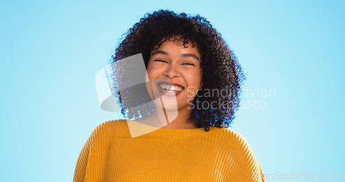 Image of Face, funny and black woman with smile, excited and cheerful against a blue studio background. Portrait, African American female and lady with freedom, laughing and carefree with happiness and joyful