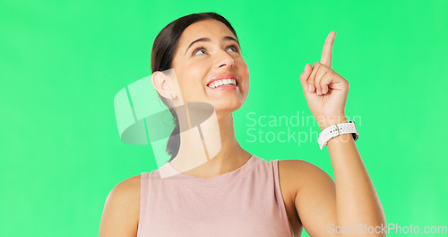 Image of Happy, woman face and pointing up to show promotion and product placement in green screen. Happiness, smile and model gesture to advertising and commercial deal in isolated studio background