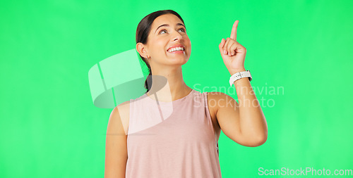 Image of Woman face, pointing up and green screen with happiness and smile showing mockup for advertisement. Portrait, isolated and studio background with a happy young female point to show promotion deal