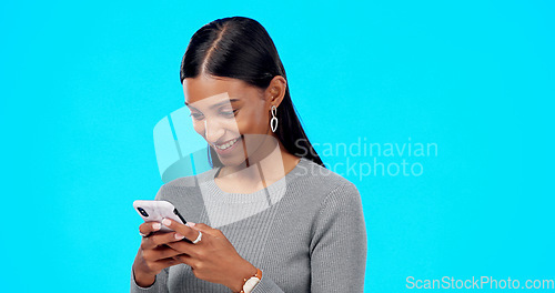 Image of Phone, games and woman typing isolated on blue background for social media, networking and web gaming. Funny indian person or gen z online user on mobile app, smartphone or cellphone in studio mockup