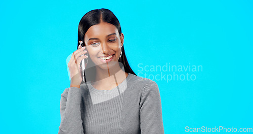 Image of Happy, woman and phone call communication on blue background, studio and backdrop for contact. Indian female, model and talking on smartphone with smile, conversation and mobile networking discussion